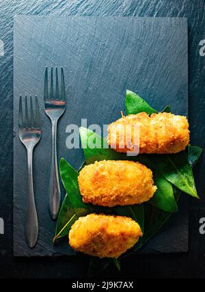 Una vista di un piatto di crocchette di antipasti servito in uno stile gourmet. Crocchette spagnole tradizionali fatte in casa. Foto Stock