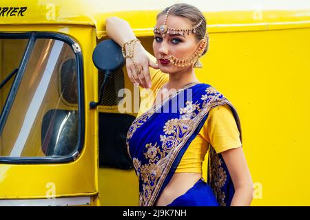 Ritratto indiano bella donna caucasica in tradizionale modello blu dress.hindu con oro kundan gioielli set bindi orecchini e piercing naso anello Foto Stock