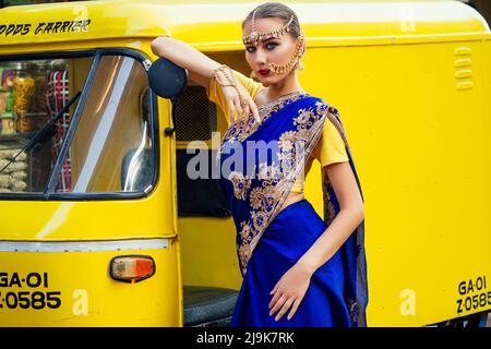 Ritratto indiano bella donna caucasica in tradizionale modello blu dress.hindu con oro kundan gioielli set bindi orecchini e piercing naso anello Foto Stock