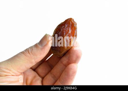Hurma secco nutriente biologico datteri chicchi di medjool, isolati a portata di mano Foto Stock