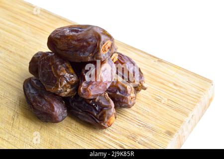 L'hurma secco nutriente fresco biologico dattera i grani di medjool, sul tagliere Foto Stock