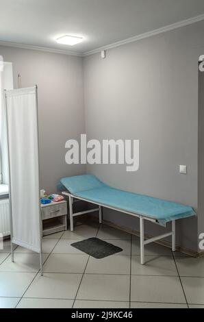 Sala moderna in clinica per l'esame e il trattamento dei pazienti. Lettino medico. Foto Stock