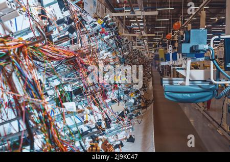 Sala di produzione con stand per la produzione di cablaggi per automobili in fabbrica moderna. Foto Stock