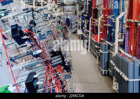 Sala di produzione con stand per la produzione di cablaggi per automobili in fabbrica moderna. Background del settore. Foto Stock