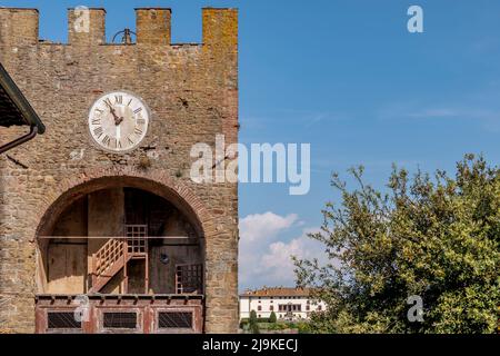 L'antica torre dell'orologio di Artimino, Prato, Italia, con sullo sfondo la villa medicea la Ferdinanda Foto Stock