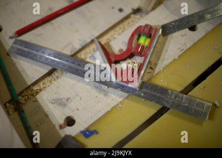 Linea e livello in officina. Strumento per le misurazioni. Dettagli di Falegnameria. Righello in acciaio. Foto Stock