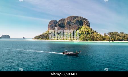 turista su una barca a coda lunga tailandese che guida attraverso le molte isole del mare delle andamane in Krabi Thailandia in una mattinata di sole vicino all'isola di Ko Poda Foto Stock