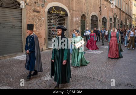 Luuca, Toscana, Italia, 08 maggio 2022 - sfilata medievale attraverso le strette stradine acciottolate di Lucca con partecipanti vestiti con costumi d'epoca. Foto Stock