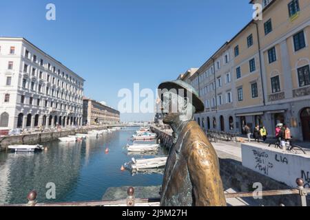 Statua di Giacomo Joyce sul Ponte Rosso un ponte sul Canal Grande di Trieste - Canal Grande, Trieste, Italia con barche ormeggiate sullo sfondo Foto Stock