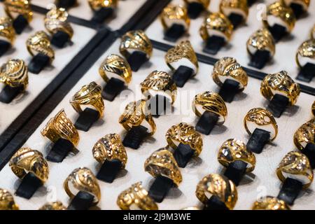 molti anelli d'oro in mostra di negozio di gioielli Foto Stock