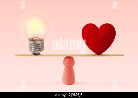 Lampadina e cuore in scala su sfondo rosa - concetto di donna e l'equilibrio tra cuore e cervello Foto Stock