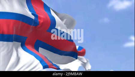 La bandiera delle Isole Faroe che sventola nel vento in una giornata limpida. Le Isole Faroe sono un arcipelago dell'Atlantico settentrionale e un paese insulare Foto Stock