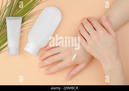 Cosmetici biologici per la cura della pelle. Una donna applica moisturizer alle sue mani. Concetto di bellezza Foto Stock