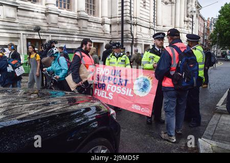 Londra, Regno Unito. 24th maggio 2022. La polizia parla con i manifestanti che bloccano una strada. Gli attivisti della ribellione dell'estinzione hanno interrotto l'annuale incontro generale del colosso petrolifero Shell presso la Metodista Central Hall di Westminster. I manifestanti si sono riuniti all'esterno, mentre diverse dozzine di attivisti hanno interrotto l'incontro all'interno della sede. Credit: Vuk Valcic/Alamy Live News Foto Stock