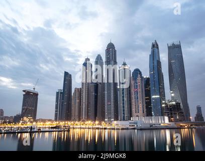 Gli alti grattacieli di Dubai Marina, la nuova e lussuosa città high tech nel Medio Oriente, che proiettano bellissimi riflessi nell'acqua, catturati prima dell'alba. Foto Stock