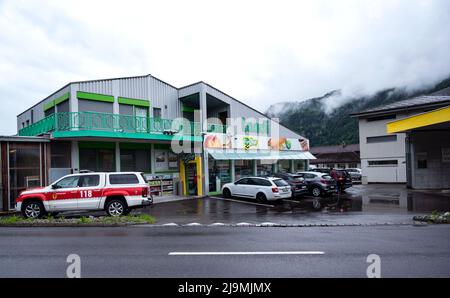 Vista della stazione di servizio con i veicoli di emergenza parcheggiati di fronte al supermercato Landi nel villaggio di Meiringen in Svizzera Foto Stock