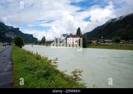 Aare il blu del fiume alpino tra strette scogliere rocciose ricoperte di vegetazione verde e alberi, catturati a Meiringen , Svizzera. Foto Stock