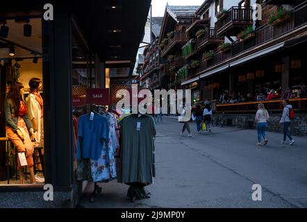 Vista dei negozi di souvenir nella principale strada dello shopping di Zermatt, un villaggio senza auto con ristoranti, chalet locali e hotel catturati in estate. Foto Stock