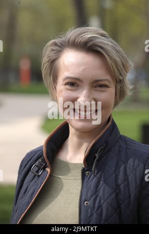 Bella donna di mezza età ritratto primo piano in abbigliamento casual moderno, contro il verde del parco estivo. Foto Stock