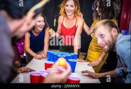 Giovani amici che giocano birra pong a ostello della gioventù - concetto di viaggio tempo libero con backpackers che hanno scollegato il divertimento in pensione - persone felici sul playf Foto Stock