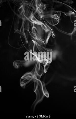 Un motivo di fumo ascendente in bianco e nero su sfondo nero, la foto potrebbe essere utilizzata come sfondo, trama di fumo, astratto, o generale st Foto Stock