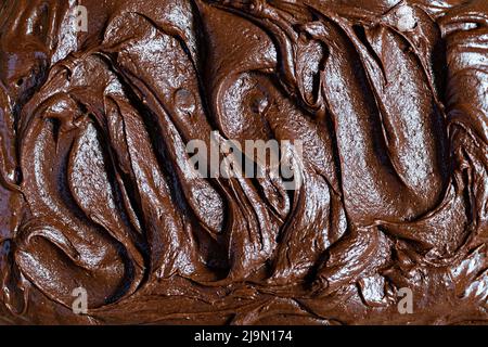 Consistenza al cioccolato (mousse) con pezzi di gocce di cioccolato. Pasta cruda per la preparazione di dessert americano brownie, vista dall'alto. Foto Stock