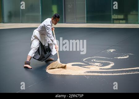 Londra UK, 24 maggio 2022. Una performance dal vivo nella turbine Hall di Tate Modern dell'acclamato artista Lee Mingwei intitolato il nostro labirinto ispirato alla visita dei templi in Myanmar. Due ballerini con campane legate alle caviglie trasformano il semplice atto di spazzare in una performance contemplativa e gesturale che si muove lentamente mentre spazzano i grani di riso in modello . Il nostro Labirinto è attivo dal 26 maggio -15 giugno. Credit. amer Ghazzal/Alamy Live News Foto Stock