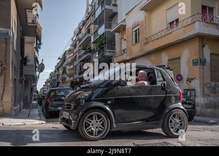 Conducente con gomito sul finestrino della sua Smart auto ad Atene Foto Stock