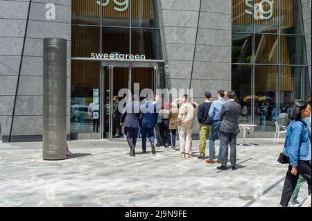 La linea di lavoratori d'ufficio e altri aspettano di prendere i loro pranzi fuori dal ristorante Sweetgreen a Hudson Yards a New York lunedì 23 maggio 2022. (© Richard B. Levine) Foto Stock