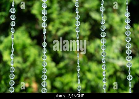 Decorazione con perline trasparenti su sfondo di verde sfocato Foto Stock