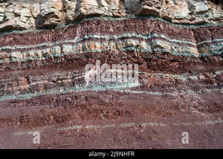 Strati colorati di argilla e pietra nella sezione di suolo, varie formazioni rocciose e strati di suolo Foto Stock