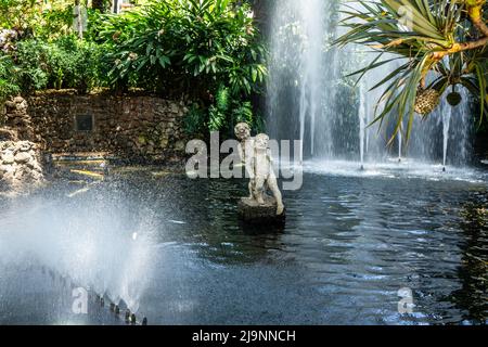 Una statua di marmo di due ragazzi che giocano in una cascata nei Giardini comunali di Funchal, Madeira. Scultore António Maria Ribeiro. Foto Stock