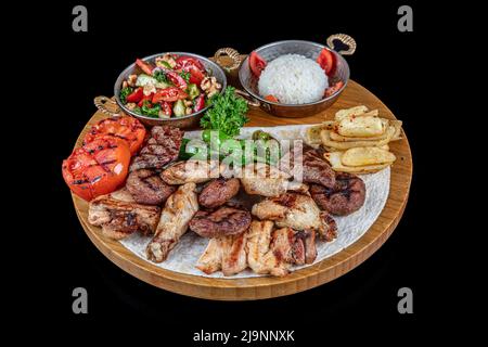 Cucina turca kebab misto. Shish kebab, shaverma, pollo alla griglia. Piatti di cucina orientale, sdraiati su pita pane e decorati con verdure e verdure Foto Stock