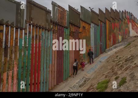 Tijuana, Messico. 21st maggio 2022. Una famiglia cammina lungo il muro che sorge sulla spiaggia al confine tra Messico e Stati Uniti. Il titolo 42, la normativa relativa alle pandemie che limita l'immigrazione dal Messico agli Stati Uniti, rimane in vigore per ora. Credit: Aimee Melo/dpa/Alamy Live News Foto Stock