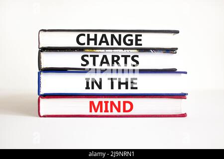 Il cambiamento inizia nel simbolo della mente. Parole di concetto il cambiamento inizia nella mente sui libri su uno sfondo bianco bello tabella. Business, motivazionale Foto Stock