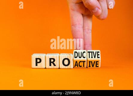 Simbolo proattivo e produttivo. L'uomo d'affari trasforma i cubi e cambia la parola di concetto produttiva a Proactive. Bellissimo sfondo arancione. Affari, Foto Stock