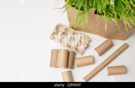 I rifiuti domestici di cartone e carta si trovano su un tavolo bianco Foto Stock