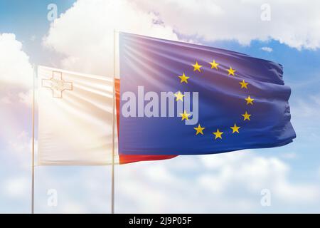 Cielo azzurro soleggiato e bandiere dell'Unione europea e di malta Foto Stock