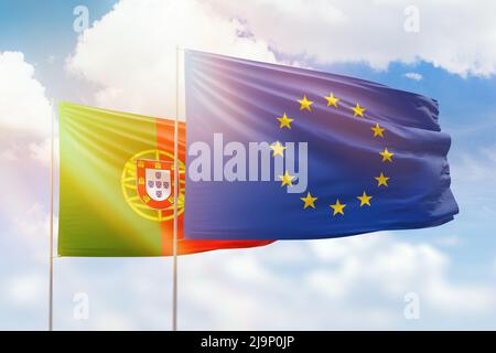Cielo azzurro soleggiato e bandiere dell'Unione europea e del portogallo Foto Stock