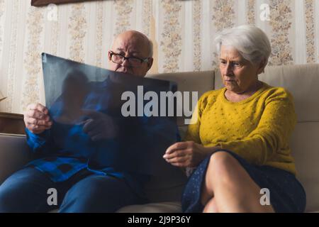 coppia ansiosa anziano che guarda i risultati dei raggi x a casa medio full shot salute e il concetto di supporto. Foto di alta qualità Foto Stock