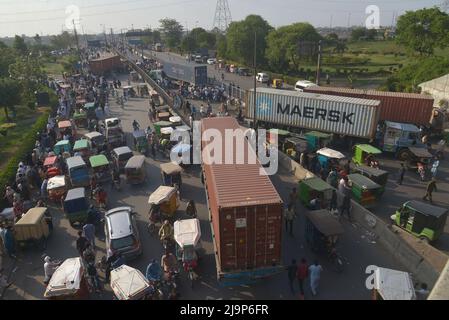 24 maggio 2022, Lahore, Punjab, Pakistan: I pendolari pakistani cercano di attraversare un ponte sul fiume Ravi lungo una strada parzialmente bloccata da container da autorità locali per ostacolare la mobilità prima del sit-in pianificato ad Islamabad dall'ex primo ministro pakistano del Pakistan Tehreek-e-INSAF (PTI), Imran Khan, a Lahore. Il principale partito di opposizione del Pakistan, guidato dal primo ministro recentemente estromesso Imran Khan, ha accusato la polizia di aver detenuto centinaia di suoi sostenitori in incursioni che sono iniziate all'inizio di martedì prima di un importante sit-in pianificato dall'ex leader, dagli alti membri del partito e dalla polizia Foto Stock