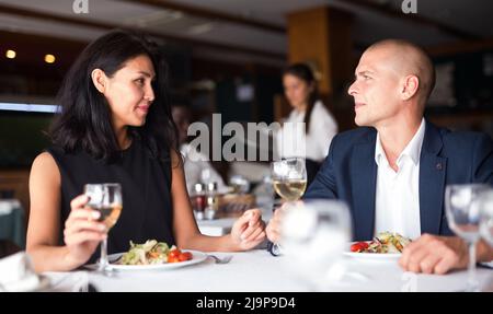 uomo e donna felici che mangiano in un moderno caffè Foto Stock