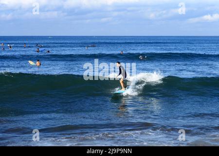 Un giovane surfista che cavalca un'onda a Batu Bolong Beach a Canggu, Bali, Indonesia Foto Stock