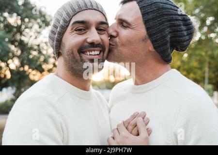 Coppia di uomini gay maturi che hanno momento tenero all'aperto - Focus sulla faccia sinistra dell'uomo Foto Stock