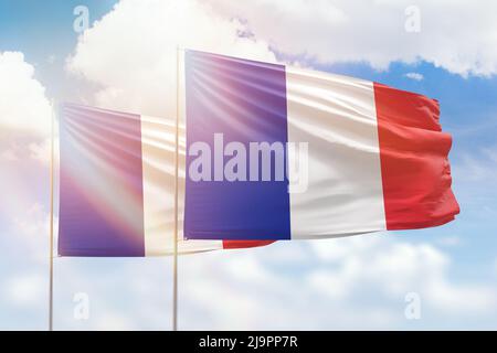 Cielo azzurro soleggiato e bandiere di francia e francia Foto Stock