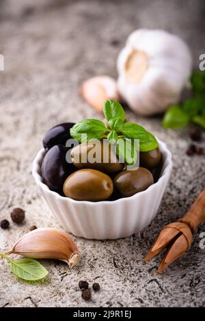 Ciotola con olive greche verdi e nere Foto Stock