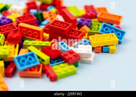 Primo piano di un edificio colorato in plastica su sfondo blu, concetto di scuola e istruzione, vista ad angolo alto, sfondo blu Foto Stock