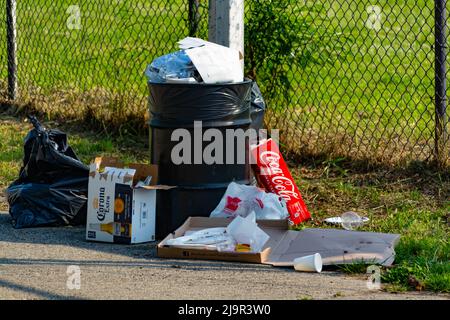 Il paesaggio disseminato di Brooklyn: Immondizia piena di rifiuti in mezzo al Trash sparso su Green Grass Foto Stock
