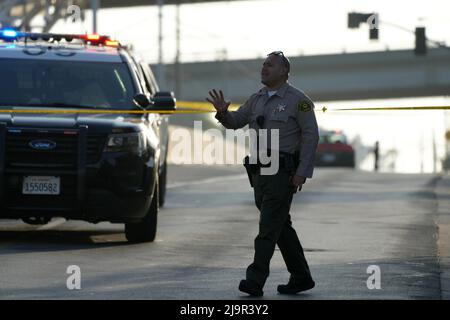 Un agente del Dipartimento dello sceriffo della contea di Los Angeles controlla il luogo della sparatoria che coinvolge un ufficiale della California Highway Patrol a Ford Blvd. E Third St., martedì 24 maggio 2022, a Los Angeles. Foto Stock