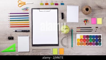 Torna a scuola nota libro, matite, Lope, mela verde su tavola di legno Foto Stock